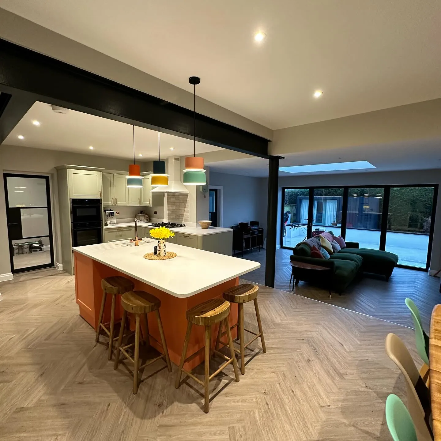 A large kitchen with a center island next to a living room.