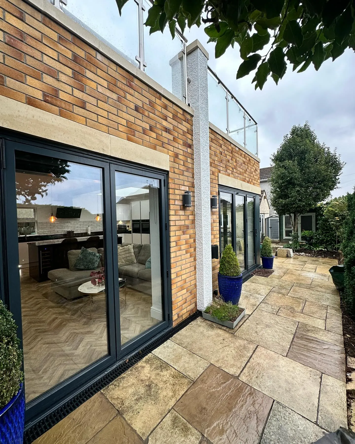 A patio with a brick wall and glass doors.