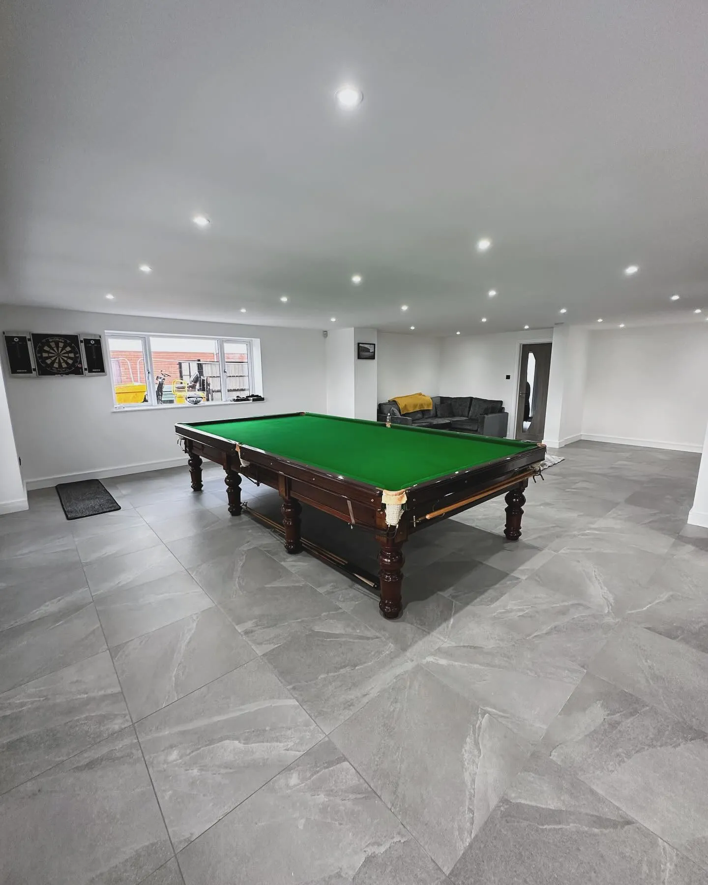 A room with a pool table and a couch.