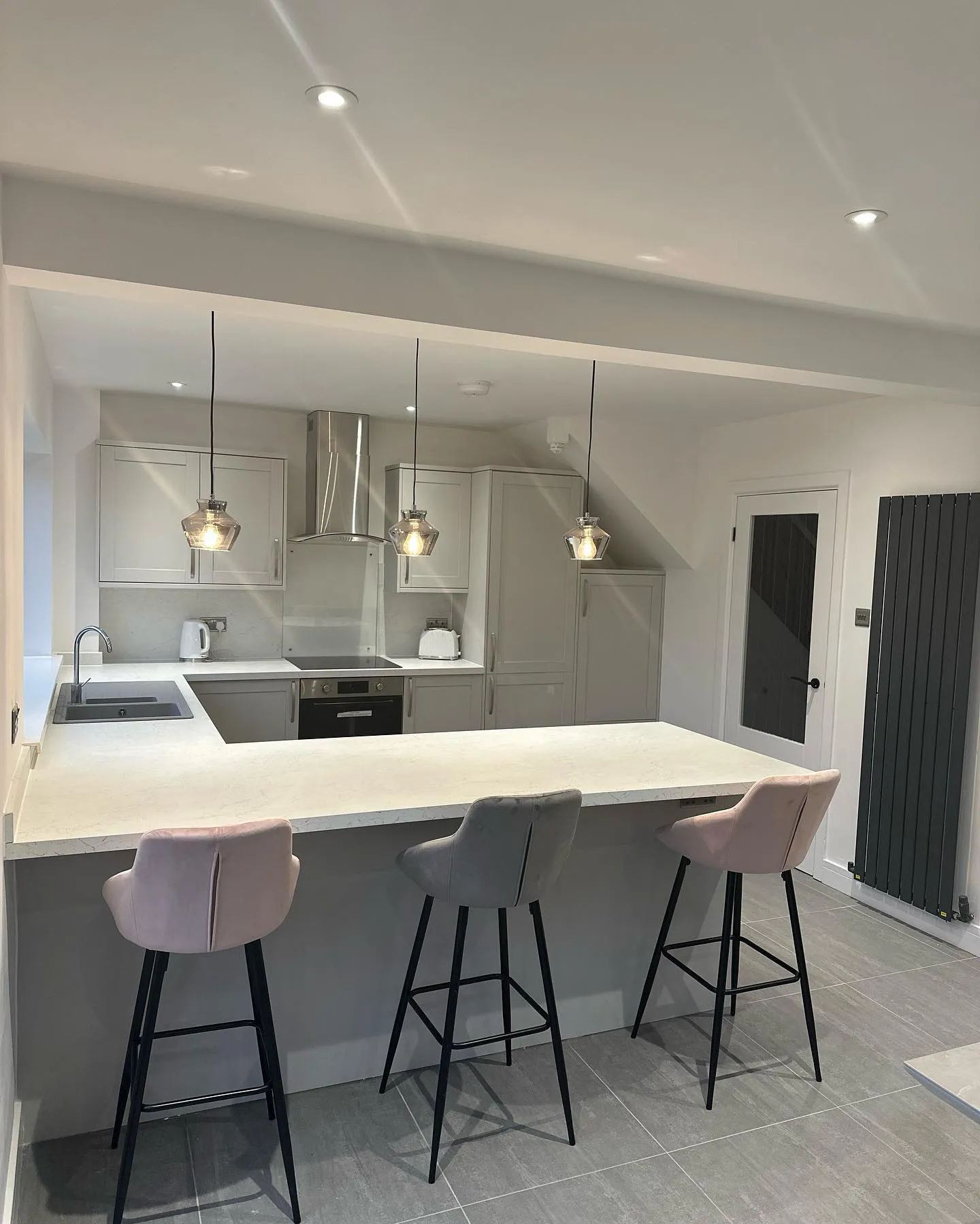 A kitchen with two bar stools next to a counter.