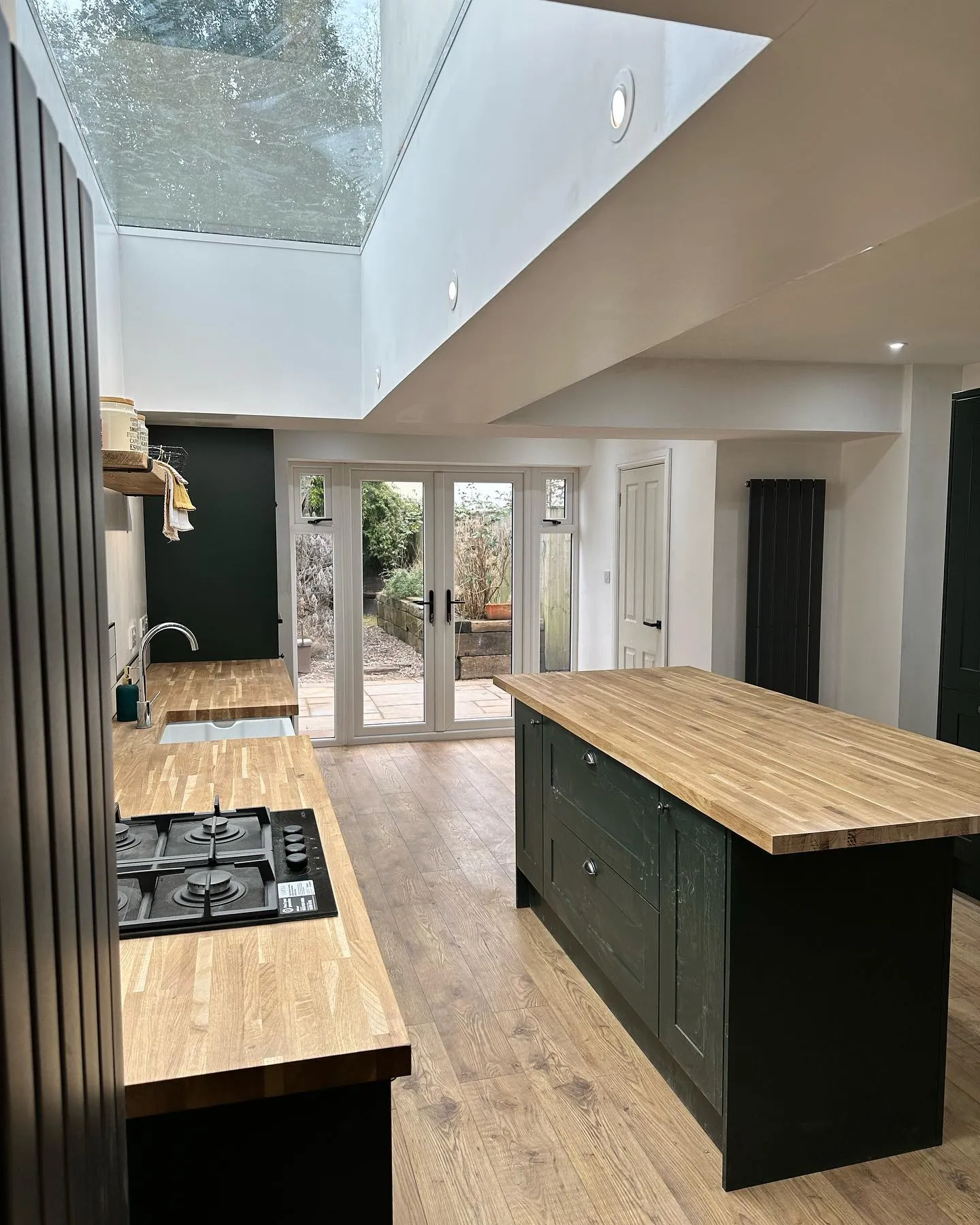 A kitchen with a stove top oven sitting under a skylight.