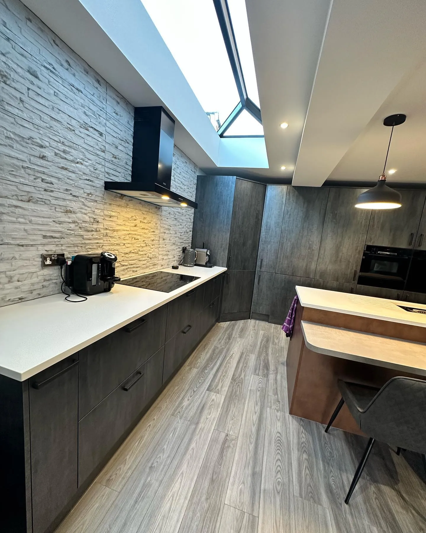 A modern kitchen with a skylight above it.