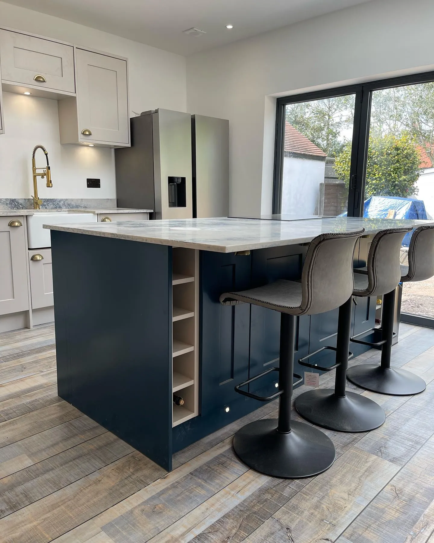 A kitchen with a center island and two bar stools.